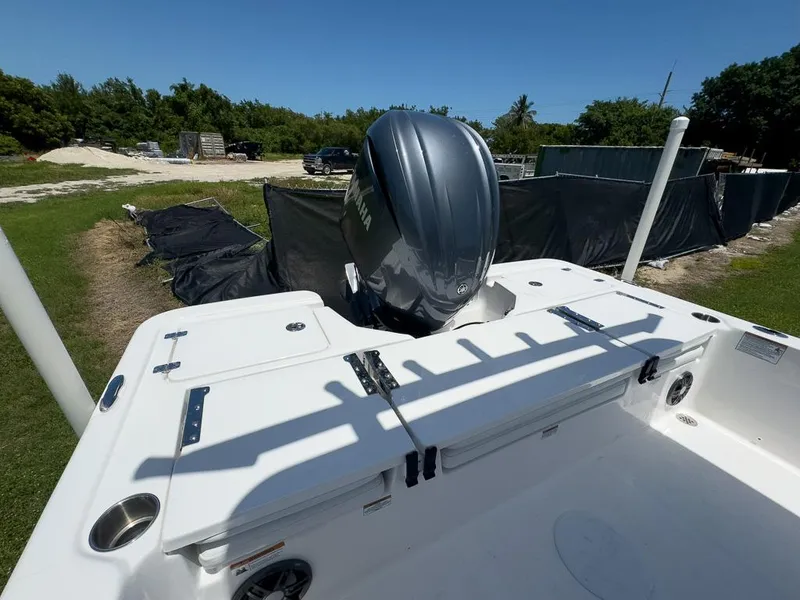 Slide: The Image of 2025 Sea Fox 231 Bay Fox boat with outboard motor, parked outdoors. - 13