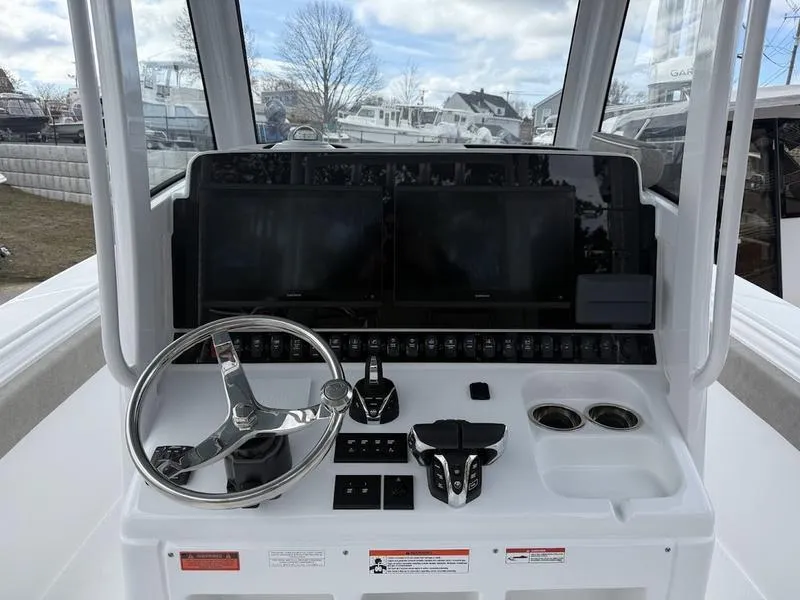 Slide: The Image of 2025 Sea Hunt Gamefish 28 Coffin Box helm with dual screens and steering wheel. - 13