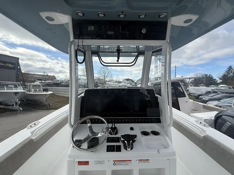 Slide: The Image of 2025 Sea Hunt Gamefish 28 Coffin Box boat console with steering wheel and controls. - 14