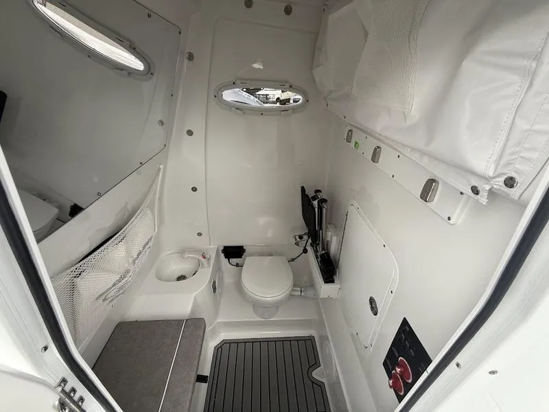 Slide: The Image of Interior of 2025 Sea Hunt Gamefish 28 Coffin Box boat, featuring compact bathroom amenities. - 18