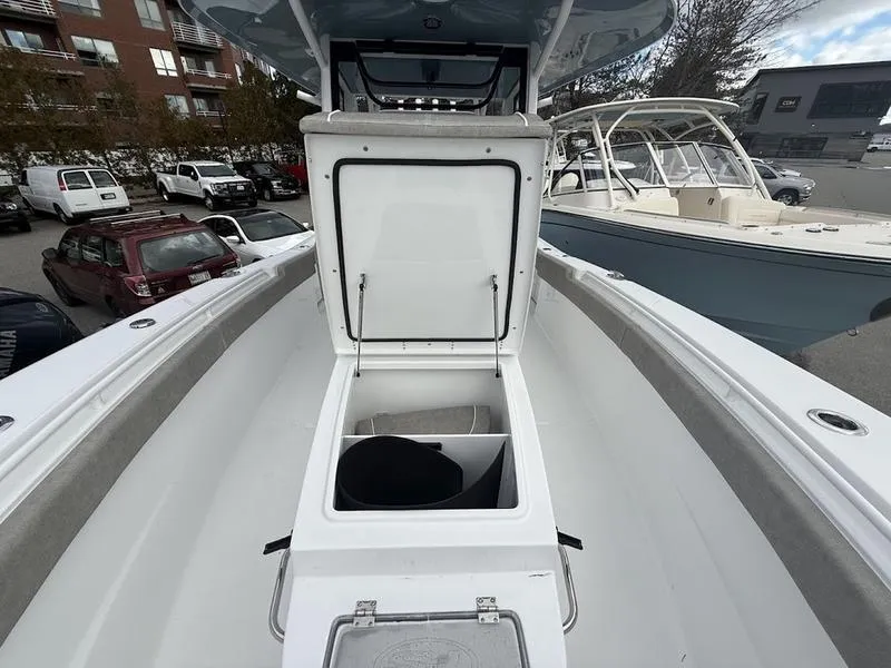 Slide: The Image of 2025 Sea Hunt Gamefish 28 Coffin Box, open storage compartment, marina background. - 19