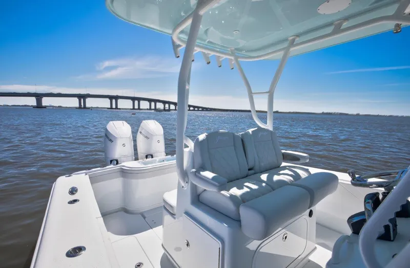 Slide: The Image of 2025 Yellowfin 32 Offshore boat on water, bridge in background, clear sky. - 12