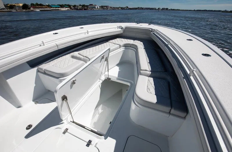 Slide: The Image of 2025 Yellowfin 32 Offshore boat with open storage compartment on calm water. - 13