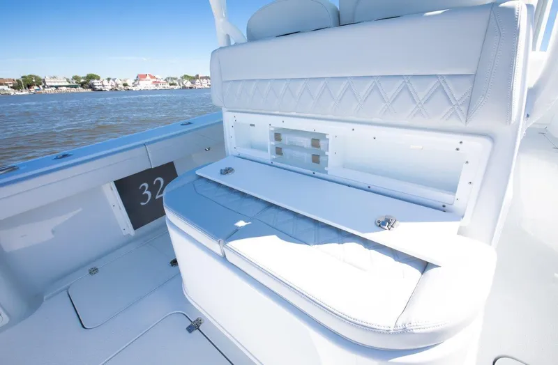Slide: The Image of 2025 Yellowfin 32 Offshore boat interior with white seating and ocean view. - 16