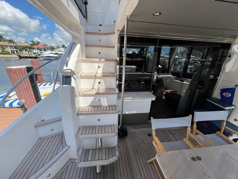Slide: The Image of 2018 Princess F55 yacht interior with stairs and seating area, docked at marina. - 35