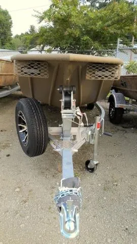 Slide: The Image of 2024 G3 16 FL boat trailer, front view, parked on gravel. - 3