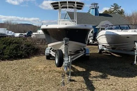 Slide: The Image of 2025 Robalo 200 CC boat on trailer, parked outdoors near other boats. - 5