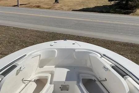 Slide: The Image of 2025 Robalo 200 CC boat bow with seating, parked near a road. - 7