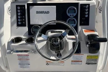 Slide: The Image of 2025 Robalo 200 CC boat dashboard with Simrad display and steering wheel. - 8