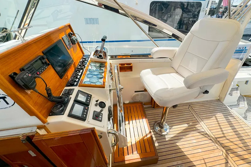 Slide: The Image of Grand Banks 38 Eastbay EX 1995 helm with white captain's chair and wooden dashboard. - 13