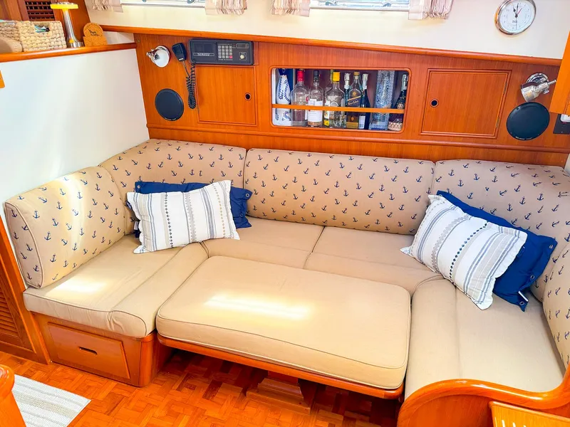 Slide: The Image of Cozy interior of 1995 Grand Banks 38 Eastbay EX with nautical-themed sofa and wooden cabinetry. - 25