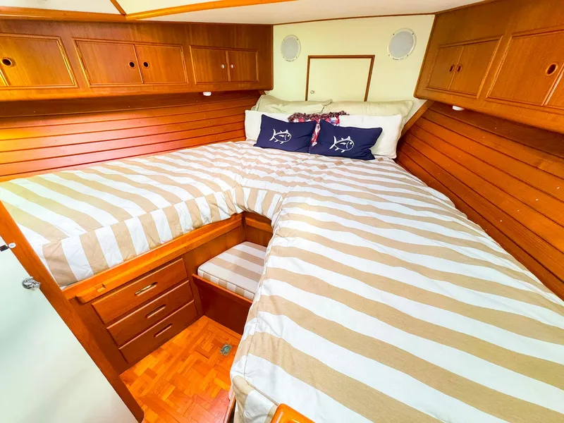 Slide: The Image of Cozy cabin interior of 1995 Grand Banks 38 Eastbay EX with striped bedding and wooden cabinetry. - 32