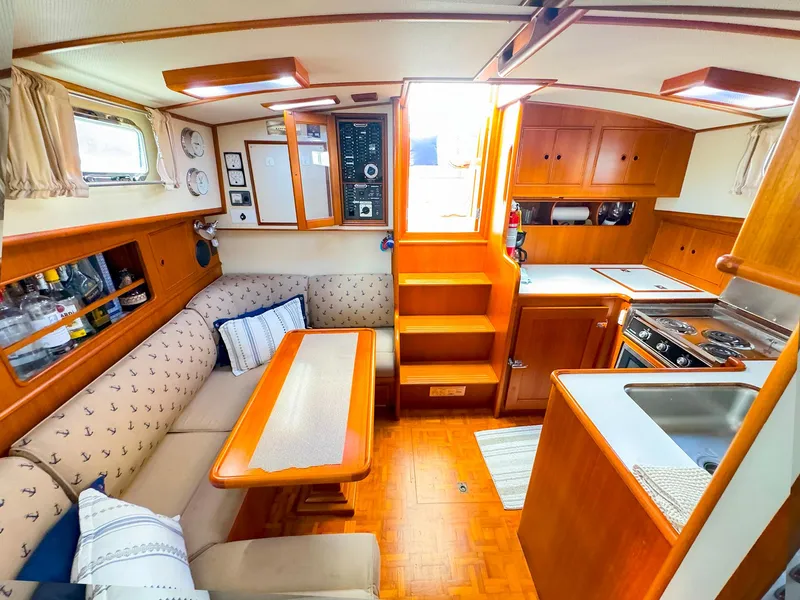 Slide: The Image of Interior of 1995 Grand Banks 38 Eastbay EX yacht, featuring cozy seating and kitchen area. - 34
