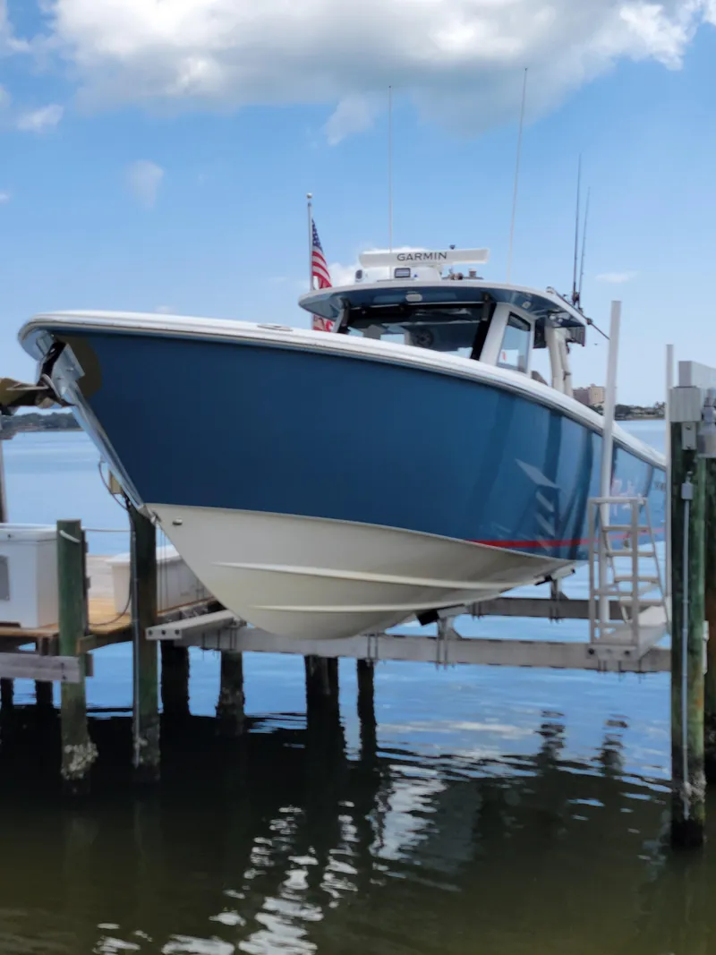 Slide: The Image of 2023 Solace 41 CS boat docked, blue hull, clear sky, American flag. - 11