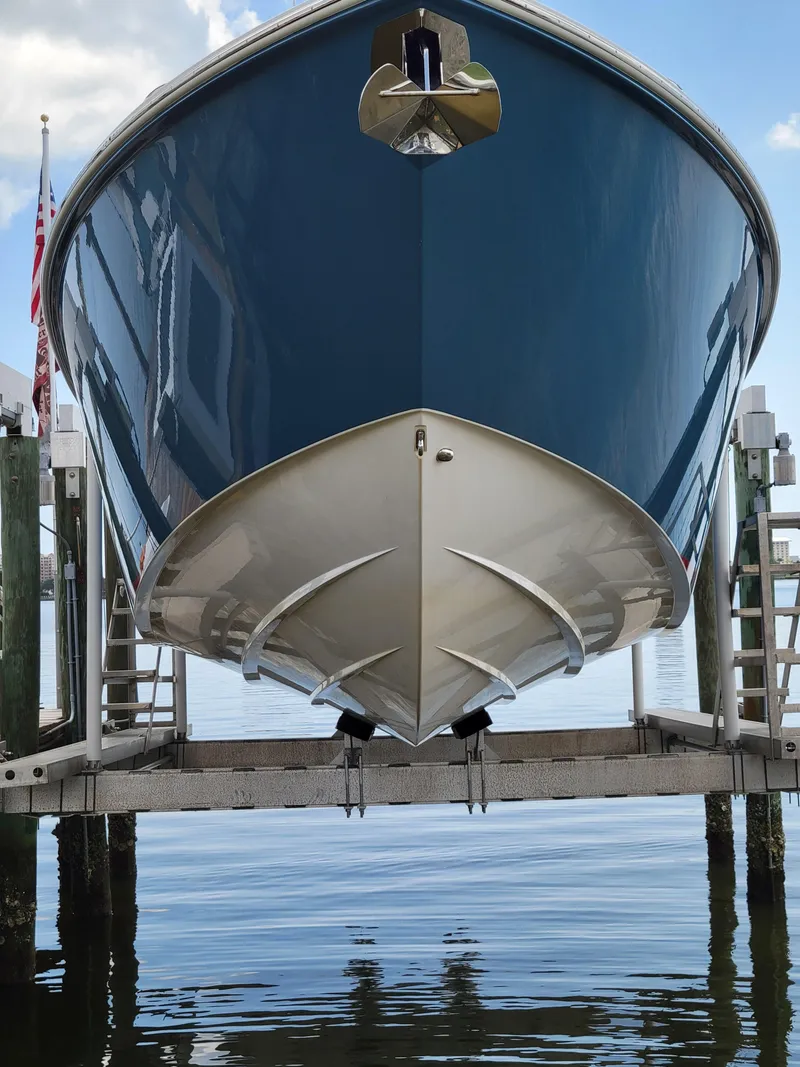 Slide: The Image of 2023 Solace 41 CS boat on lift, reflecting on calm water. - 12