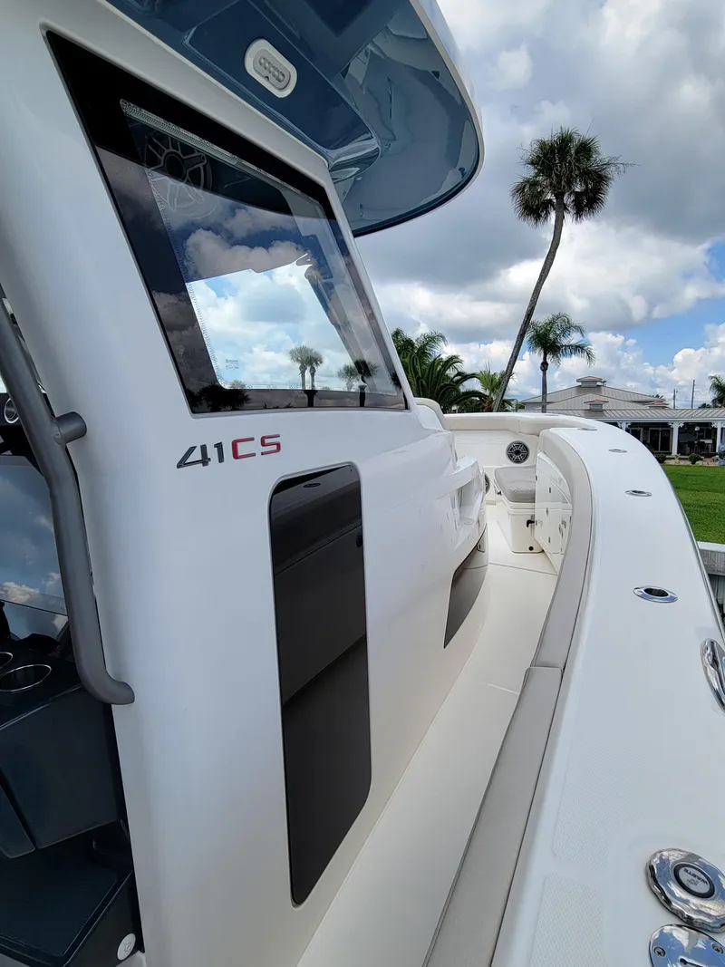 Slide: The Image of 2023 Solace 41 CS boat, sleek design, modern features, palm trees in background. - 36