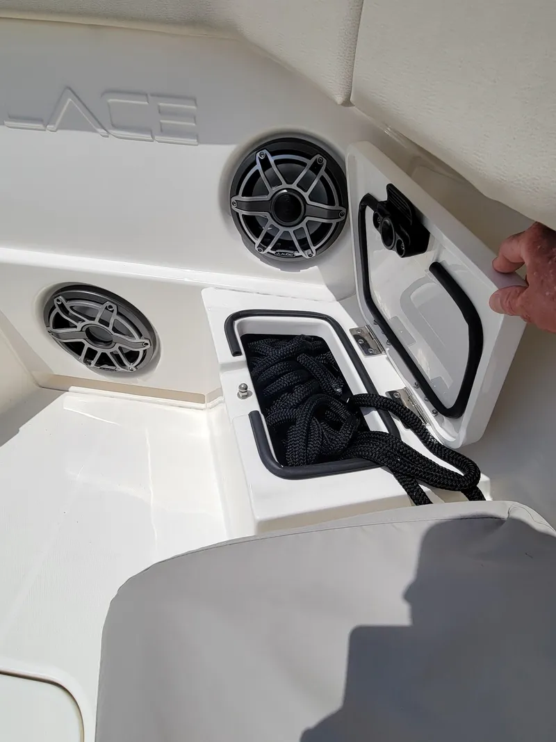 Slide: The Image of 2023 Solace 41 CS boat storage compartment with black rope and speakers. - 41