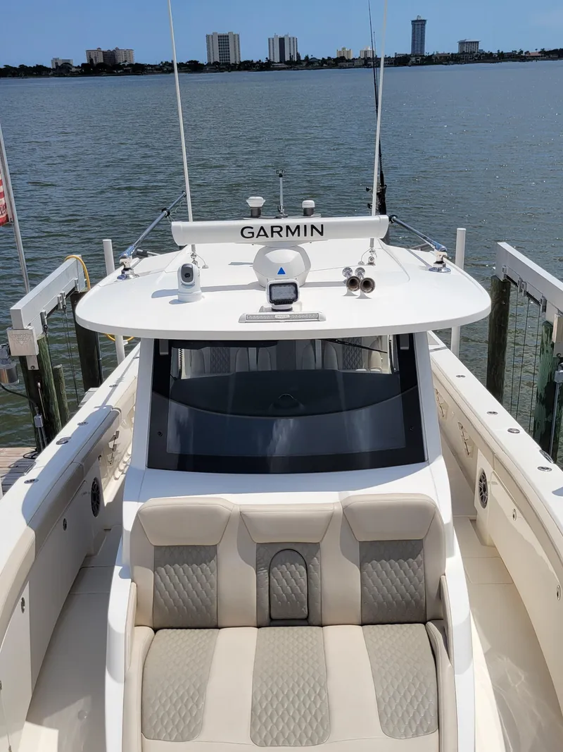 Slide: The Image of 2023 Solace 41 CS boat docked, featuring Garmin navigation, with waterfront cityscape in background. - 46
