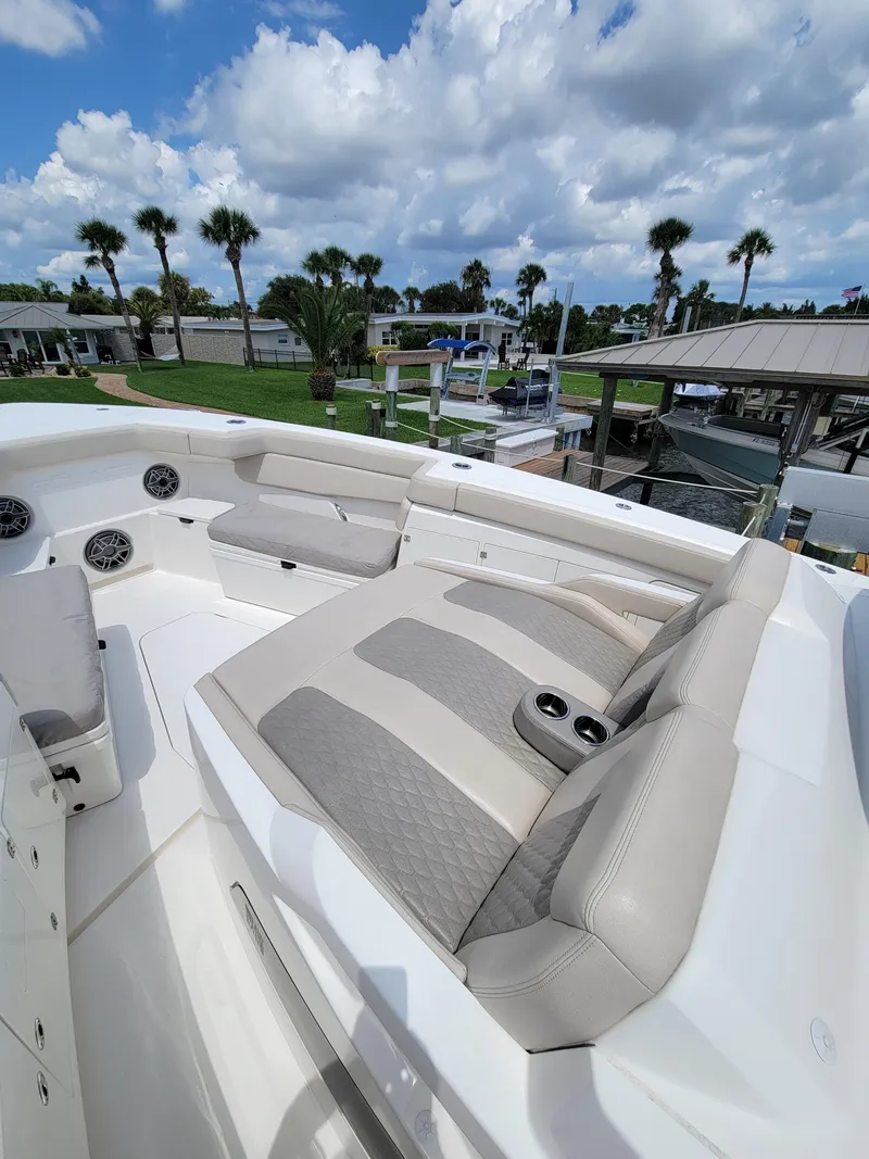 Slide: The Image of 2023 Solace 41 CS boat with luxurious seating, docked under a blue sky. - 49