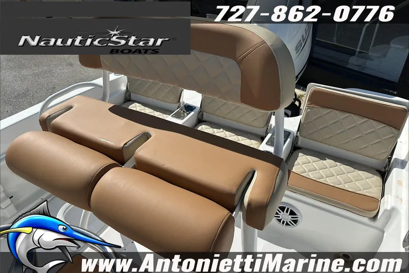 Slide: The Image of 2025 NauticStar 211 Hybrid boat seating with tan upholstery, featuring logo and contact details. - 15