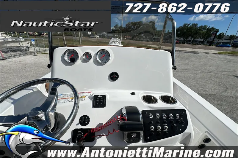 Slide: The Image of 2025 NauticStar 211 Hybrid boat dashboard with steering wheel and controls. - 16