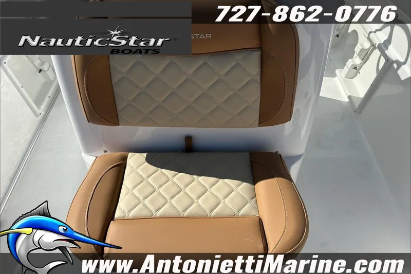 Slide: The Image of 2025 NauticStar 211 Hybrid boat seat with tan and cream upholstery, featuring logo and contact details. - 22