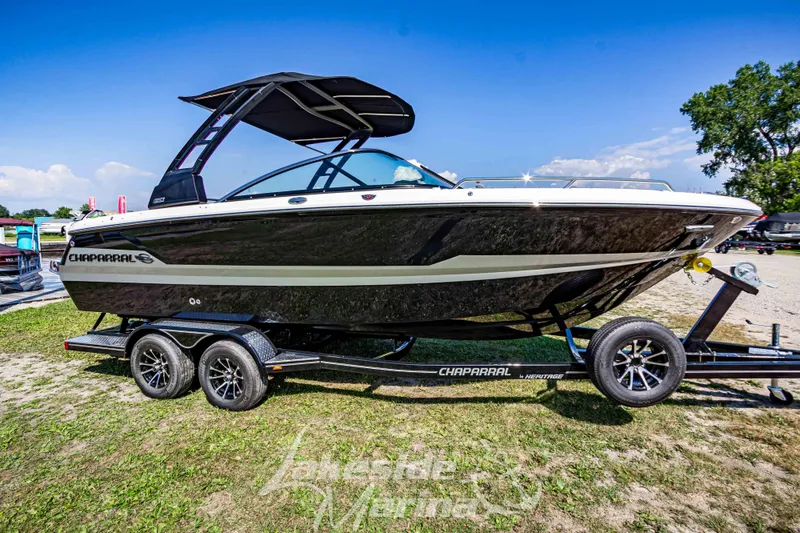 Slide: The Image of 2025 Chaparral 247 SSX boat on trailer, sleek black design, sunny outdoor setting. - 1