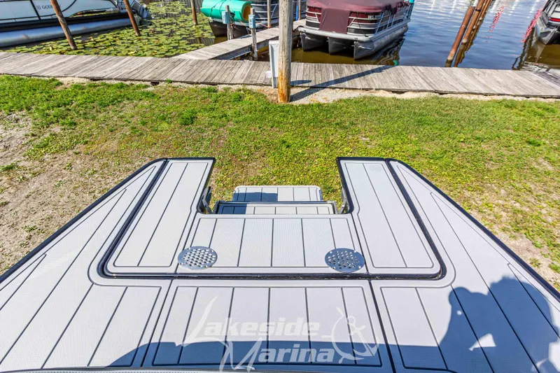 Slide: The Image of 2025 Chaparral 247 SSX boat deck at Lakeside Marina, near docked boats. - 10