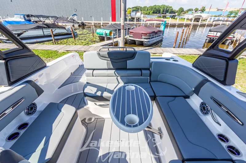 Slide: The Image of 2025 Chaparral 247 SSX boat interior with seating and table, docked at marina. - 19