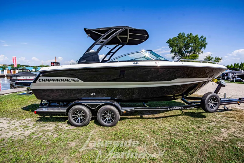 Slide: The Image of 2025 Chaparral 247 SSX boat on trailer, displayed outdoors under clear blue sky. - 2