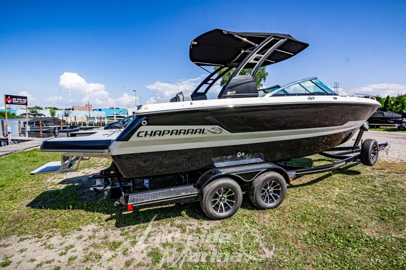 Slide: The Image of 2025 Chaparral 247 SSX boat on trailer, parked outdoors under clear blue sky. - 3