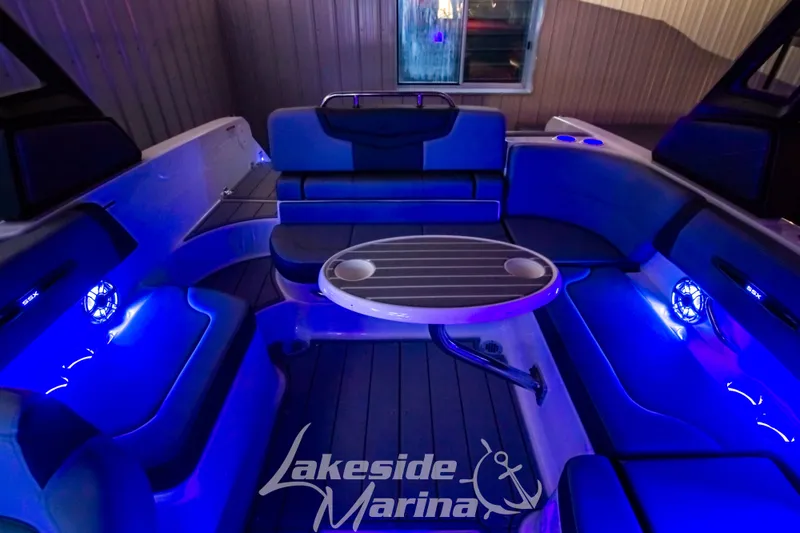 Slide: The Image of 2025 Chaparral 247 SSX boat interior with blue LED lighting and seating. - 42