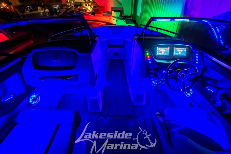 Slide: The Image of 2025 Chaparral 247 SSX boat interior with vibrant blue LED lighting at Lakeside Marina. - 43