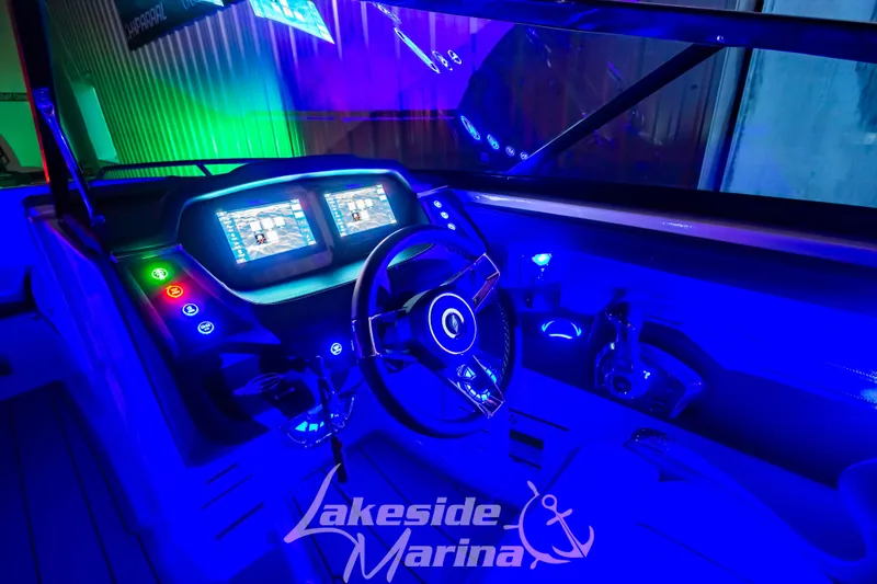 Slide: The Image of 2025 Chaparral 247 SSX boat dashboard with vibrant blue LED lighting. - 44