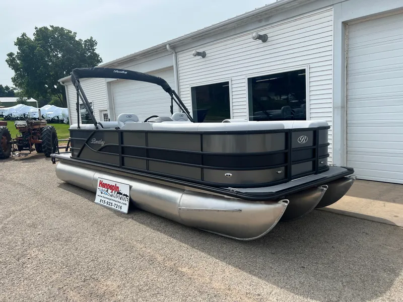 Slide: The Image of 2025 Bentley Pontoons Legacy Navigator, sleek design, parked outside a white building. - 1