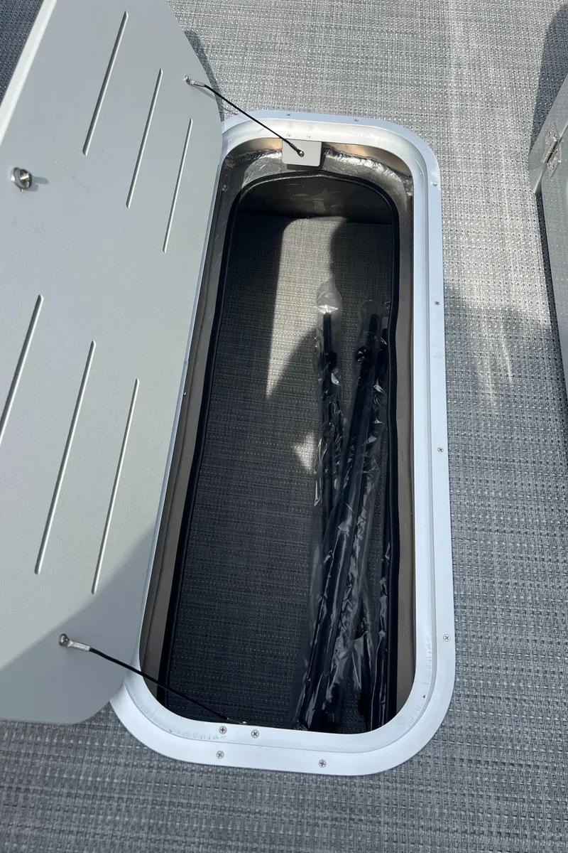 Slide: The Image of Open storage compartment in 2025 Bentley Pontoons Legacy Navigator boat. - 10