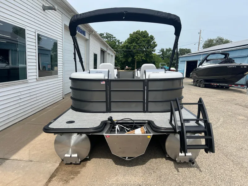 Slide: The Image of 2025 Bentley Pontoons Legacy Navigator, gray pontoon boat, docked outside dealership. - 5