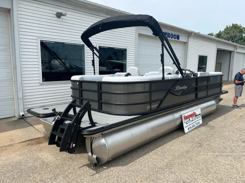 Slide: The Image of 2025 Bentley Pontoons Legacy Navigator, gray pontoon boat outside showroom. - 6