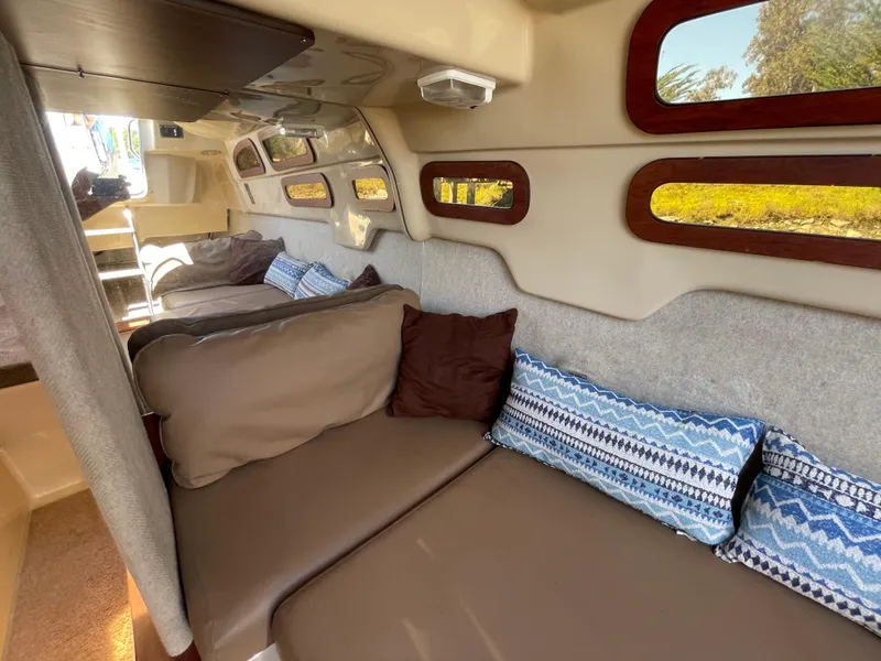 Slide: The Image of Interior of 2006 MacGregor 26M sailboat with cozy seating and decorative cushions. - 13