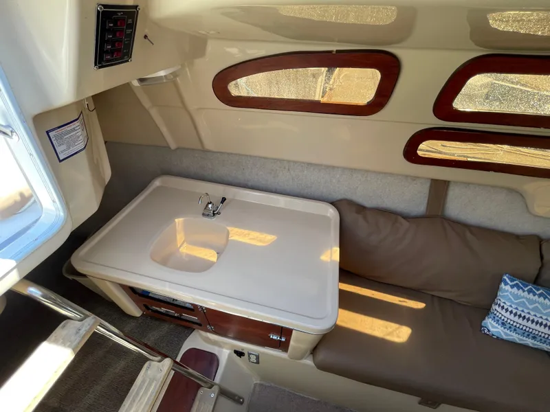 Slide: The Image of Interior of 2006 MacGregor 26M sailboat with table, seating, and windows. - 15