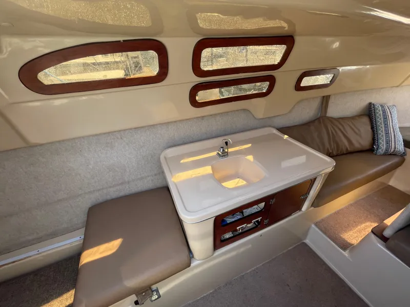 Slide: The Image of Interior of 2006 MacGregor 26M sailboat with sink and seating area. - 16