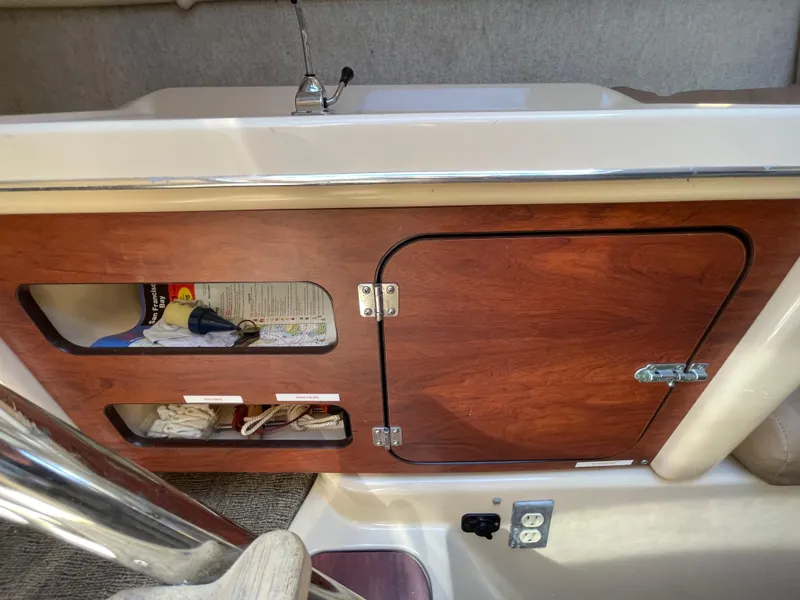 Slide: The Image of Interior of a 2006 MacGregor 26M sailboat with wooden storage cabinet and sink. - 17
