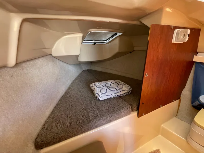 Slide: The Image of 2006 MacGregor 26M cabin interior with cozy sleeping area and small window. - 18
