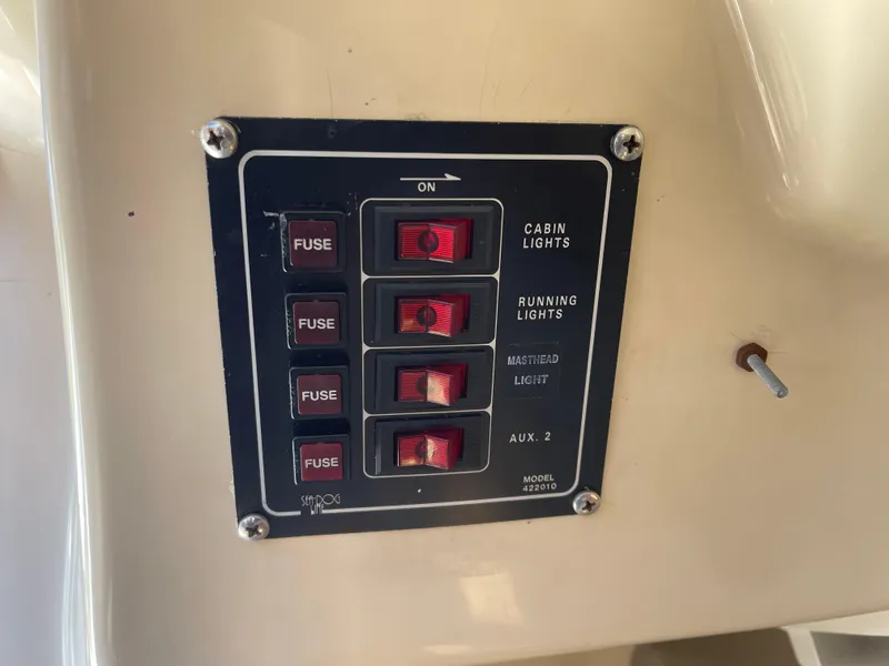Slide: The Image of Control panel of a 2006 MacGregor 26M boat with labeled switches and fuses. - 22