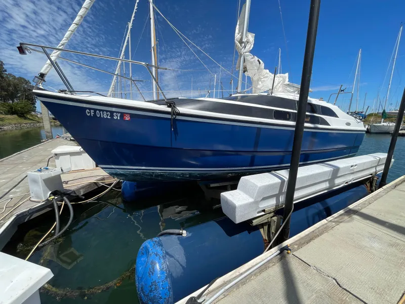 Slide: The Image of Blue 2006 MacGregor 26M sailboat docked on a sunny day. - 26
