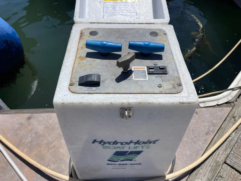 Slide: The Image of HydroHoist boat lift control panel near water, featuring blue handles and various switches. - 27