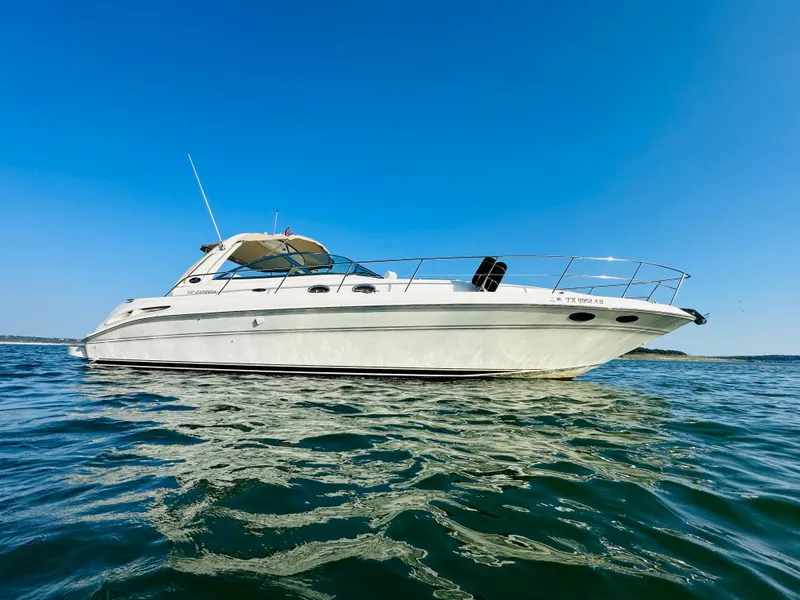Slide: The Image of 2002 Sea Ray 410 Express Cruiser on open water under clear blue sky. - 1