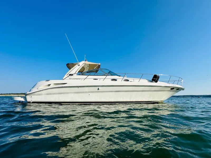 Slide: The Image of 2002 Sea Ray 410 Express Cruiser on calm water under clear blue sky. - 2