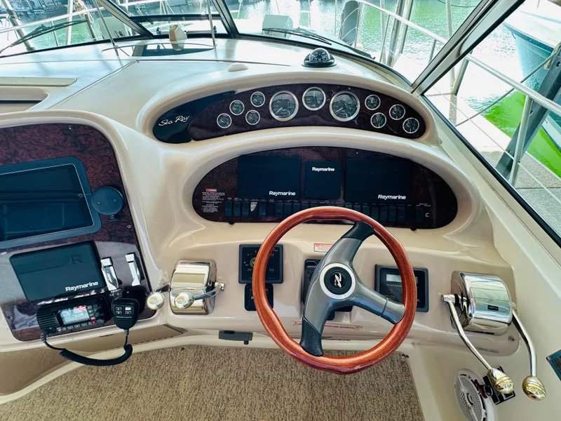 Slide: The Image of 2002 Sea Ray 410 Express Cruiser helm with wood steering wheel and Raymarine electronics. - 27