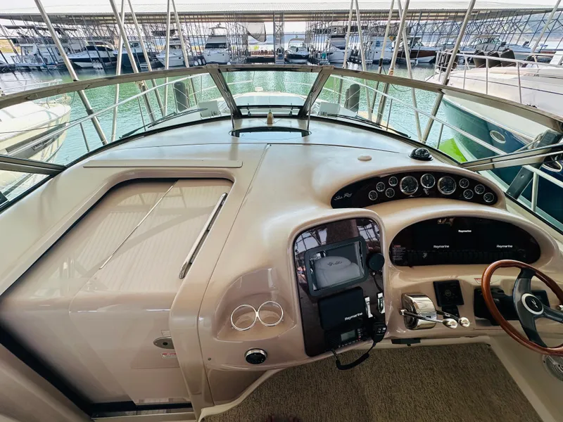 Slide: The Image of 2002 Sea Ray 410 Express Cruiser helm with gauges and controls, docked in marina. - 28